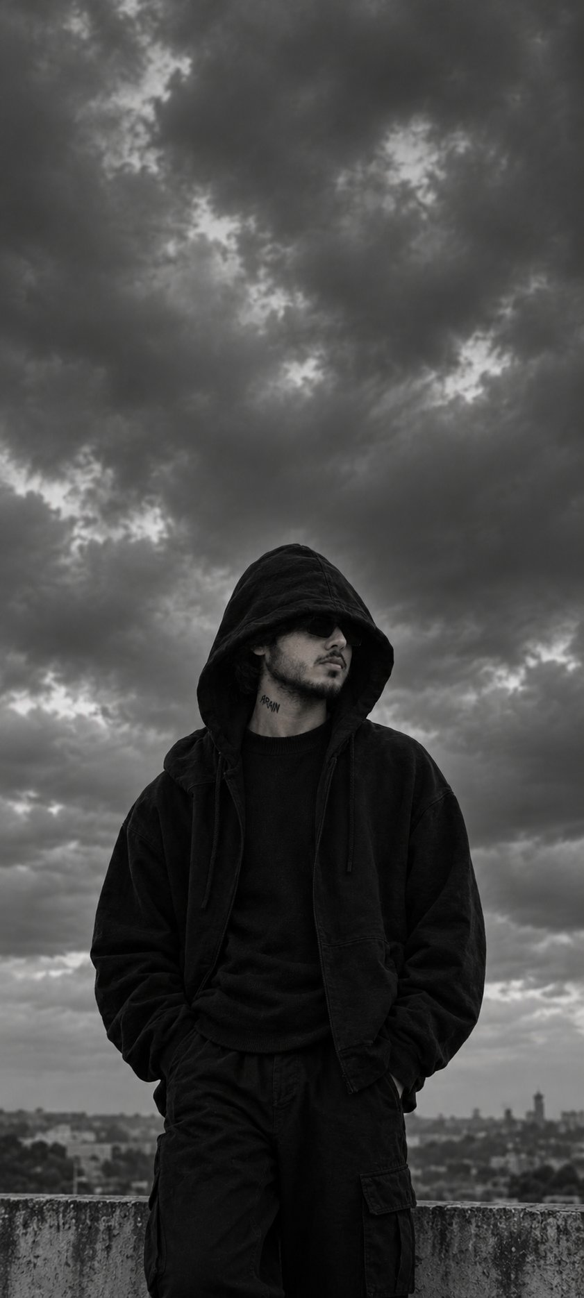 MEHAR-OG in a black hoodie under a stormy sky