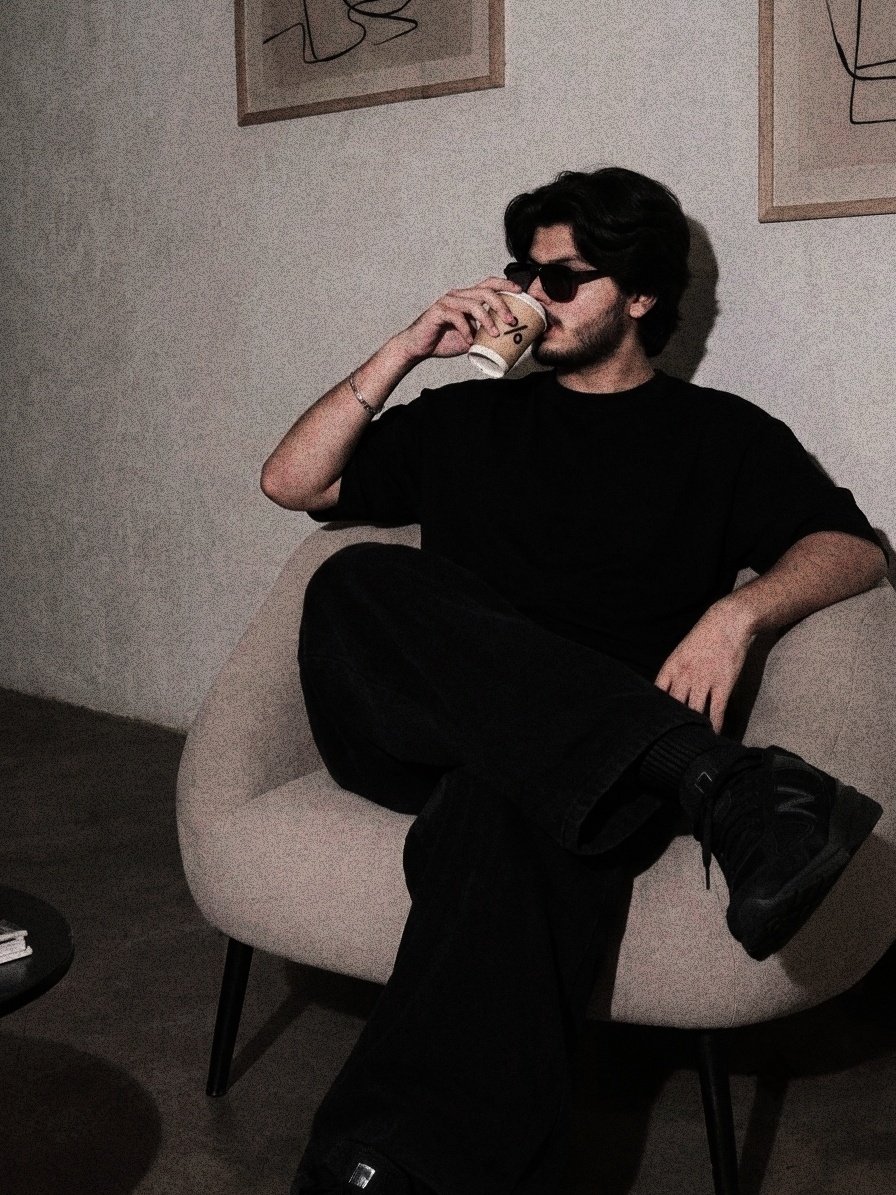MEHAR-OG relaxing with a coffee, all black outfit